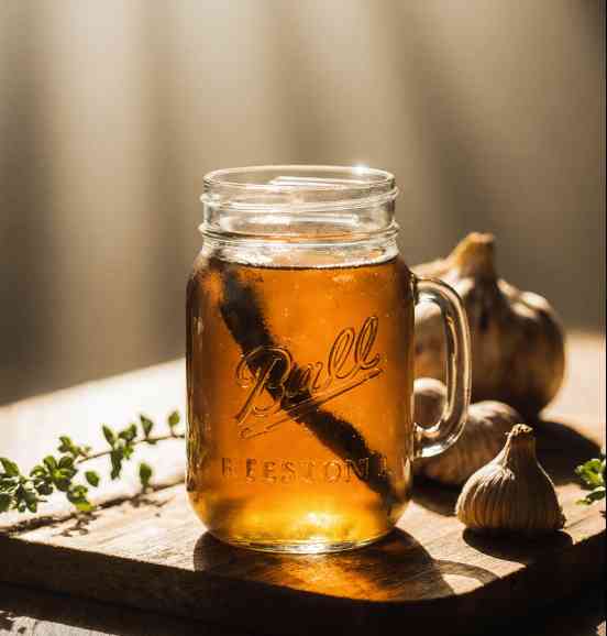Natural Antibiotic Recipe in mason jar with warm rustic background and fresh garlic